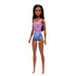 Barbie beach doll angled view, highlighting her long dark hair and gradient purple swimsuit with tropical hibiscus prints, giving a stylish beach-ready appearance.