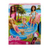 Barbie pool playset in retail packaging featuring dolls in colorful swimsuits with blue pool, pink slide, accessories, and illustrated beach background scene for display.