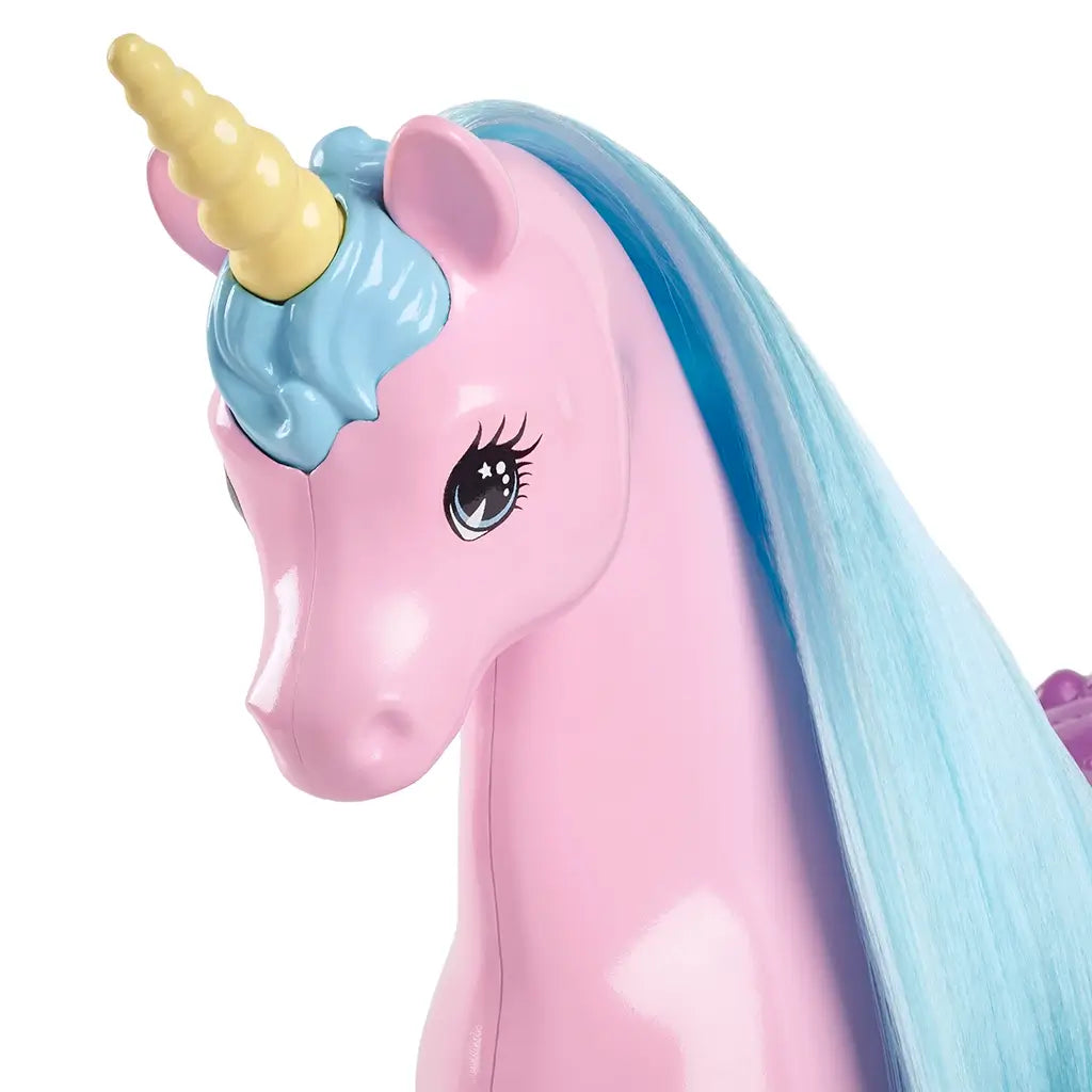 Barbie unicorn toy with glossy pink plastic body, pastel blue mane, pale yellow horn, and large painted eyes, designed for imaginative play and fantasy-themed storytelling.