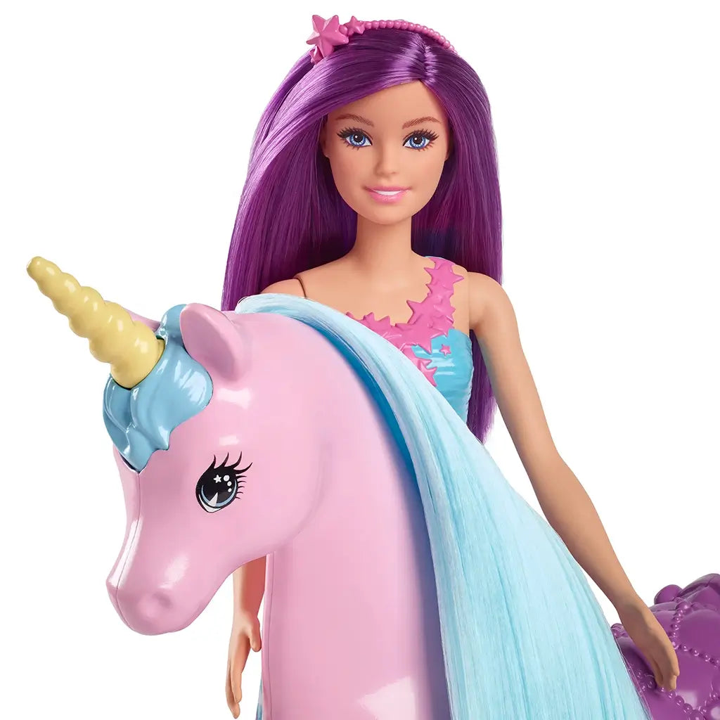 Barbie doll with bright purple hair and a teal floral dress poses closely with a pink unicorn toy featuring a shiny yellow horn and flowing pastel blue mane for fantasy play.