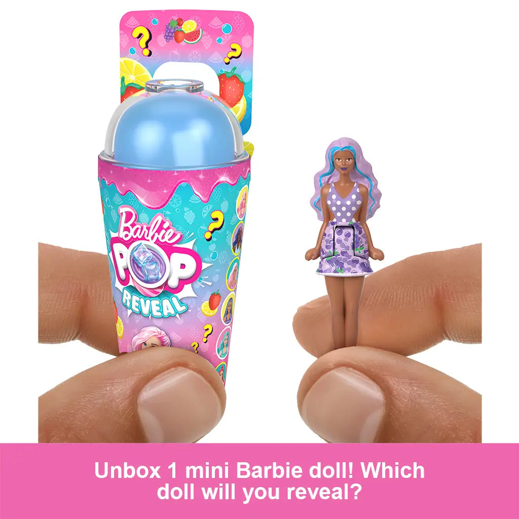 Close-up of Barbie Mini BarbieLand Pop Reveal with a hand holding a small 1.5-inch doll dressed in purple polka-dot top and skirt, shown next to the surprise cup container.