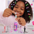 Smiling child plays with Barbie Cutie Reveal mini dolls, unmasking a unicorn-themed figure with pastel costume and tiny pet, surrounded by colorful collectible animal characters.