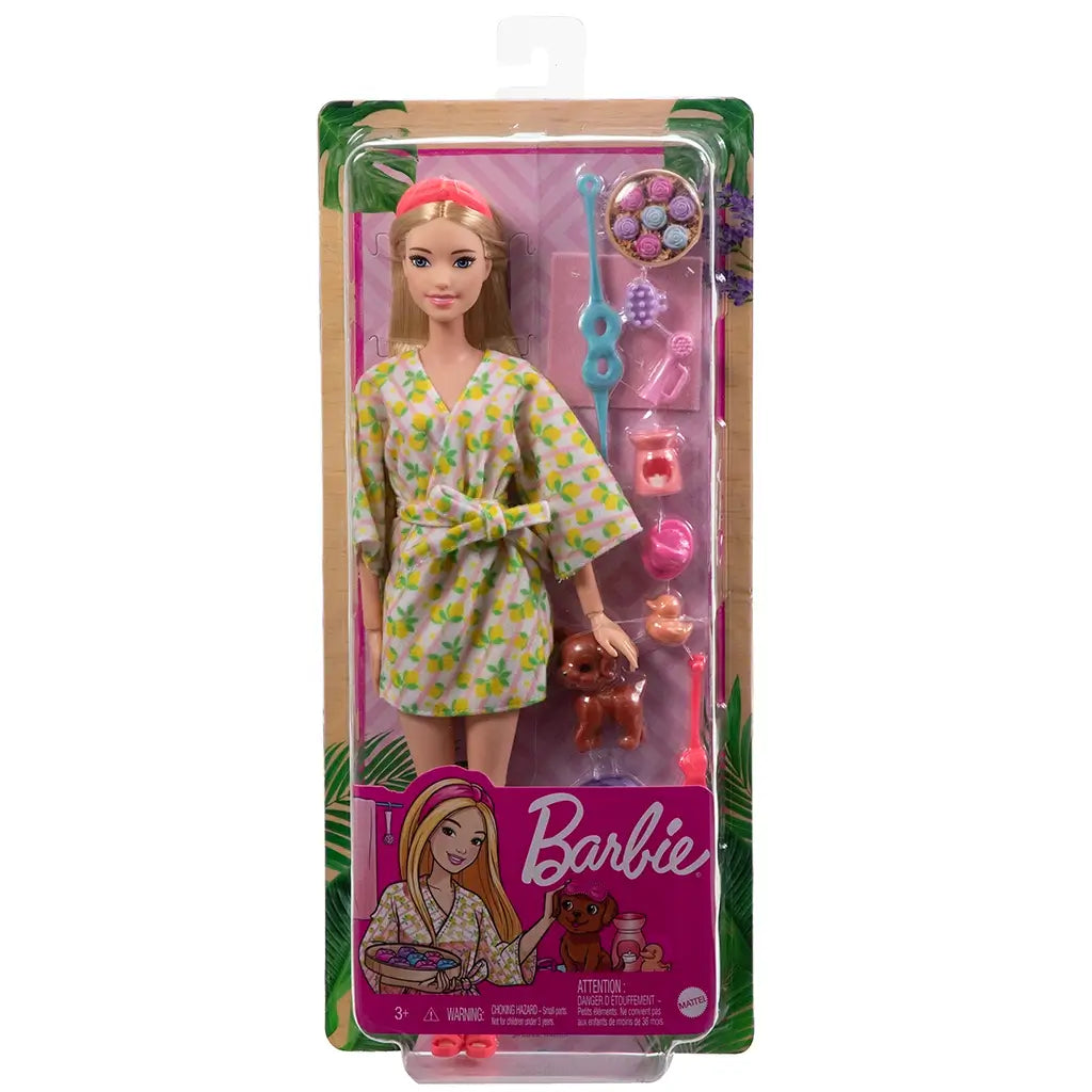 Barbie Self-Care Spa Day doll set in packaging, featuring blonde Barbie in a lemon-print robe with pink headband, spa accessories, and brown puppy figure included.