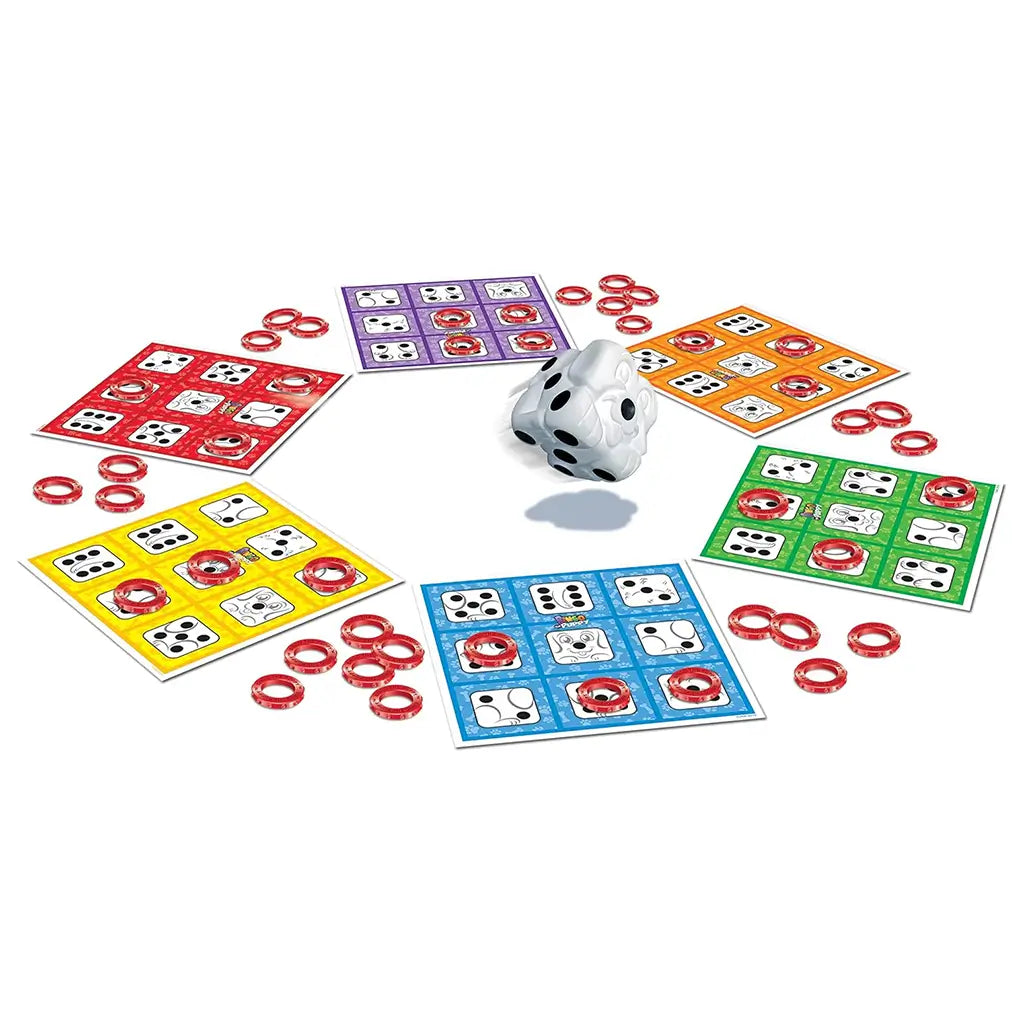 Close-up of Bingo The Puppy board game components including red, blue, green, yellow, and orange bingo cards, red ring tokens, and the puppy-shaped die positioned in the center.