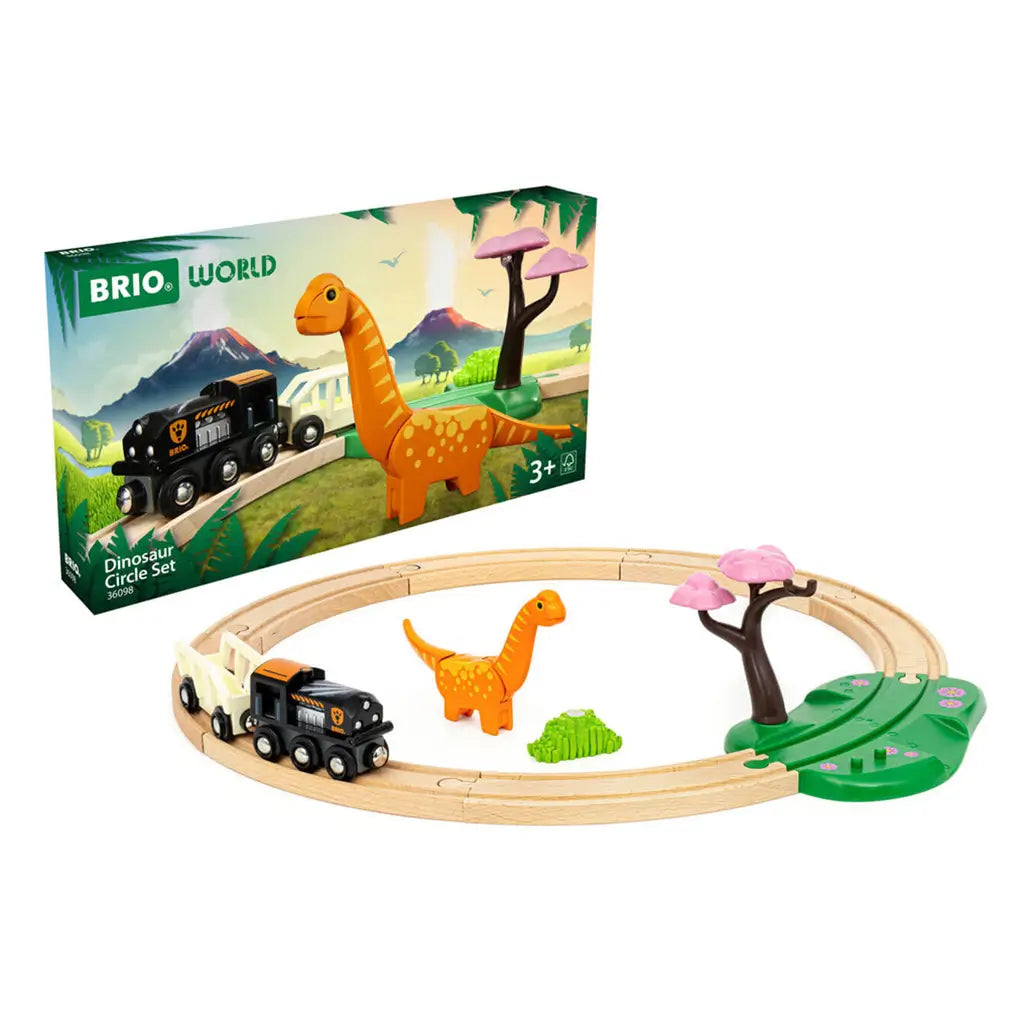 BRIO Dinosaur Circle Train Set showing circular wooden track, black locomotive, white wagon, orange dinosaur figure, green foliage, and pink tree accessory beside packaging box.