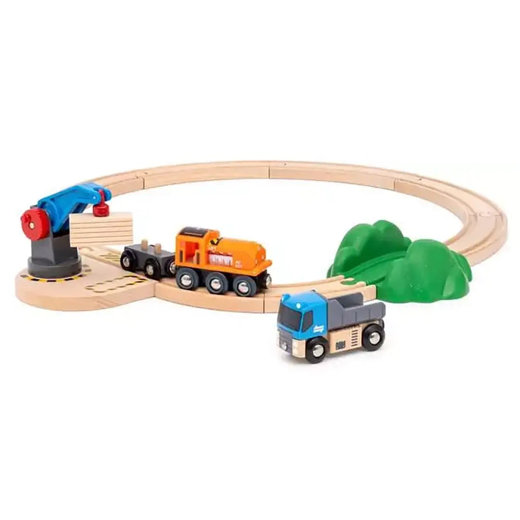 BRIO World Starter Lift and Load Set wooden train track arranged in an oval with crane, orange train, blue truck, green tunnel, and log accessory for interactive play.