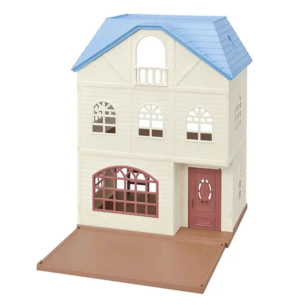 Calico Critters Sky Blue Terrace dollhouse stands three stories tall with cream walls, arched windows, blue roof, red front door, and fold-out brown play base for imaginative play.