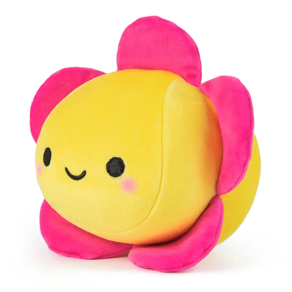 Left angle of a yellow plush flower toy with smiling face and five bright pink petals, designed for children and collectors as part of the Cheeky Chonks Bloomin Buns line.