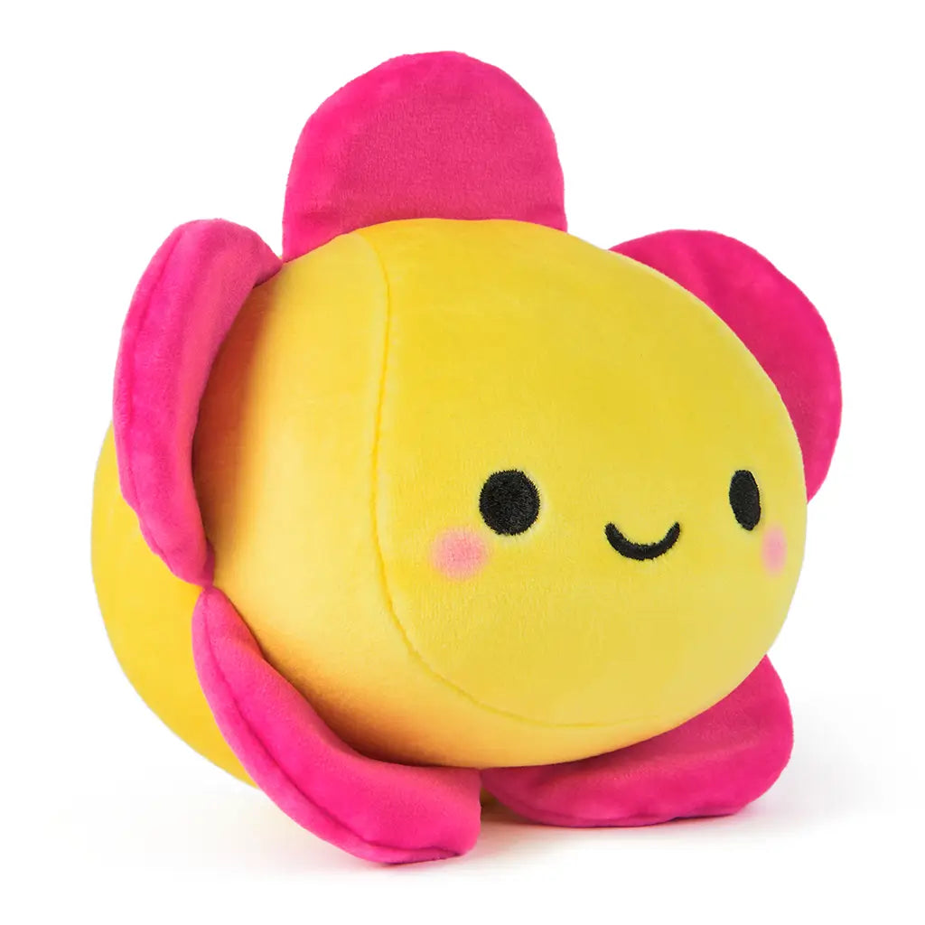 Side angle of a reversible 6-inch plush toy shaped like a cheerful yellow flower with bright pink petals and embroidered face, perfect for cuddling or gifting.