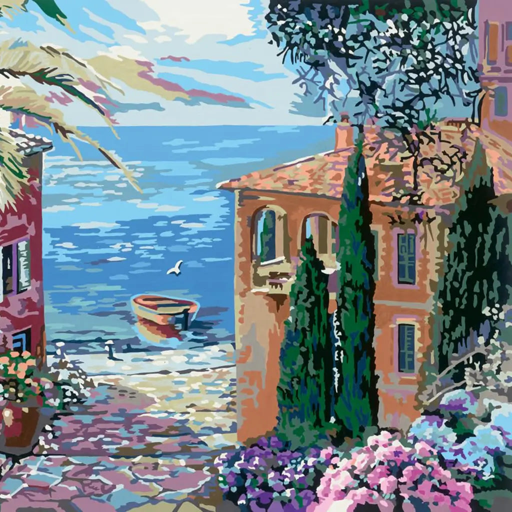 Colorful paint by numbers artwork showing a Mediterranean coastal scene with terracotta houses, lush greenery, blooming flowers, a small boat, and a seagull by the bright blue sea.