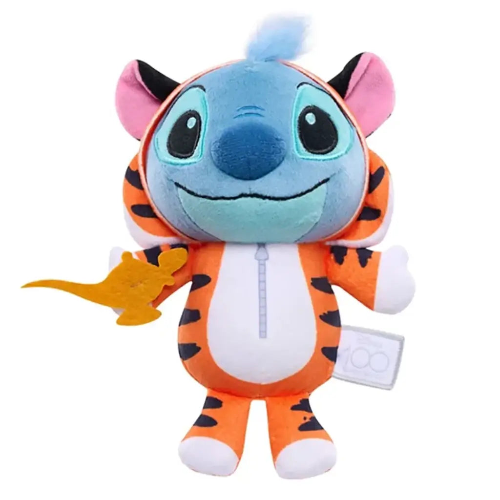 Close-up of a Disney Stitch plush figure in a detailed orange tiger-striped Rajah outfit with pink ears, blue face, and golden lamp accessory, symbolizing Disney’s 100th anniversary collection.