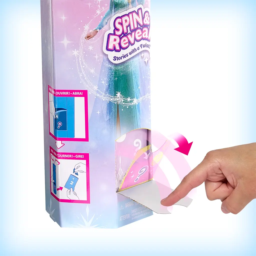 Disney Frozen Spin & Reveal Elsa doll packaging side view showing interactive surprise flap being lifted, revealing mystery accessory inside with illustrated pink and blue design.