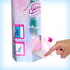 Disney Frozen Spin & Reveal Elsa doll packaging side view showing interactive surprise flap being lifted, revealing mystery accessory inside with illustrated pink and blue design.