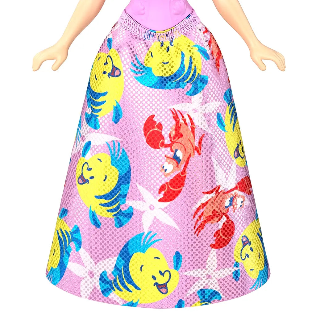 Close-up of Ariel doll’s skirt from Disney Princess Friends set, featuring Flounder and Sebastian character prints on a pink background.