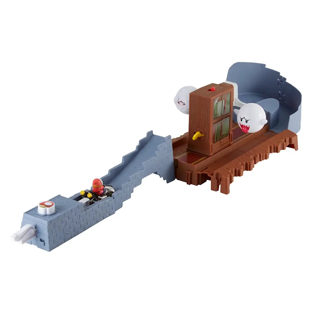 Angled view of Hot Wheels Mario Kart Boo’s Spooky Sprint set shows Shy Guy kart racing up gray ramp toward haunted library with Boo ghosts guarding the spinning bookshelf.