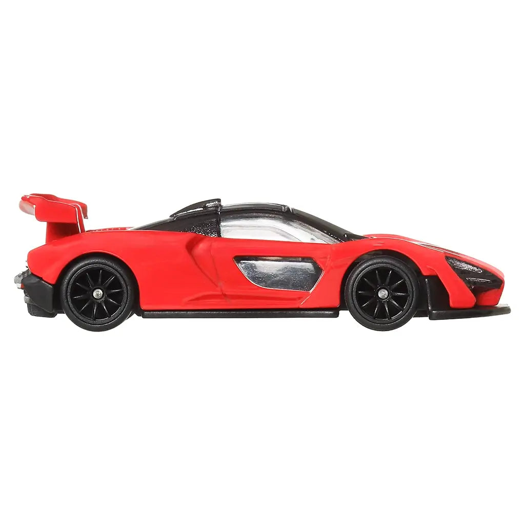 Side profile of Hot Wheels McLaren Senna 1:64 scale model in red with black wheels, clear windows, and large rear spoiler.