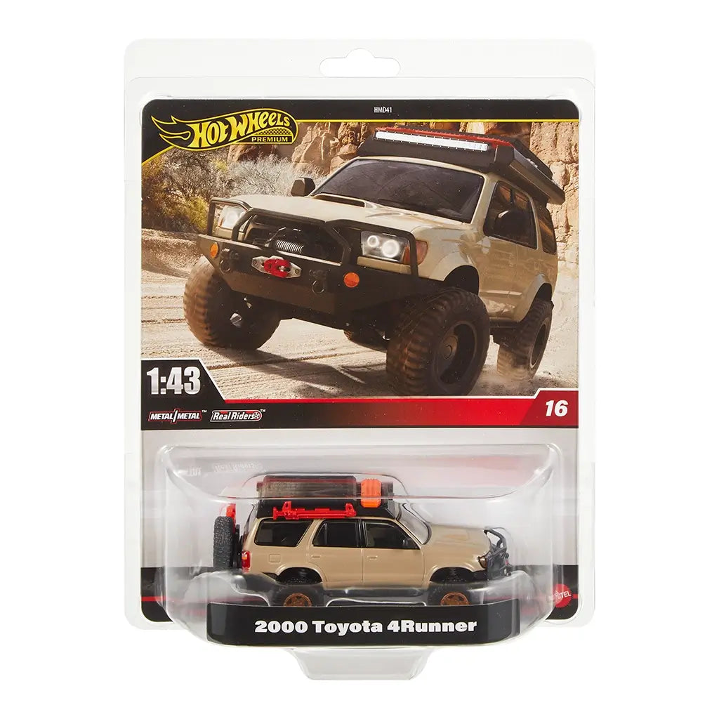 Hot Wheels Premium 2000 Toyota 4Runner diecast SUV in tan with roof gear, spare tire, and rugged details, packaged in 1:43 scale display card featuring off-road desert backdrop.
