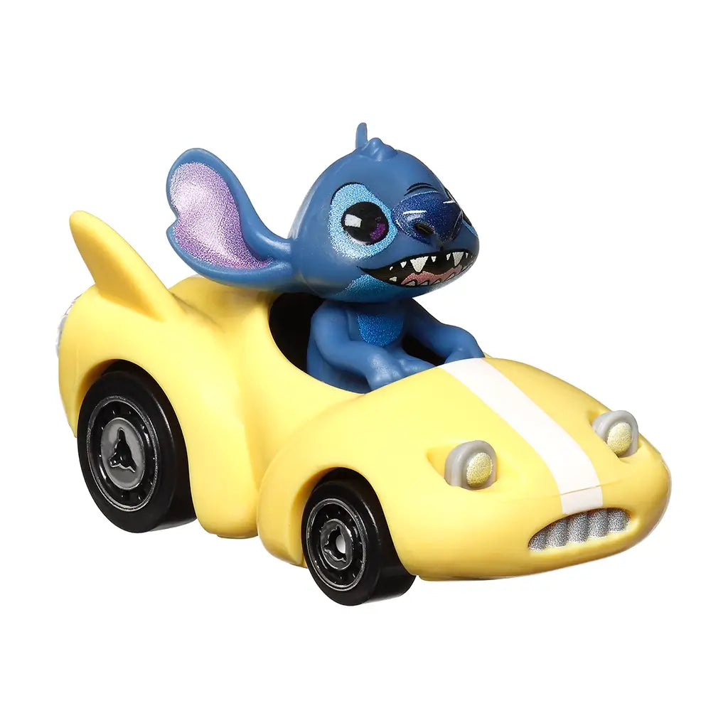 Front angled view of Hot Wheels RacerVerse Stitch diecast car, yellow body with white stripe, large blue Stitch driver figure smiling, and black wheels with silver hubs.