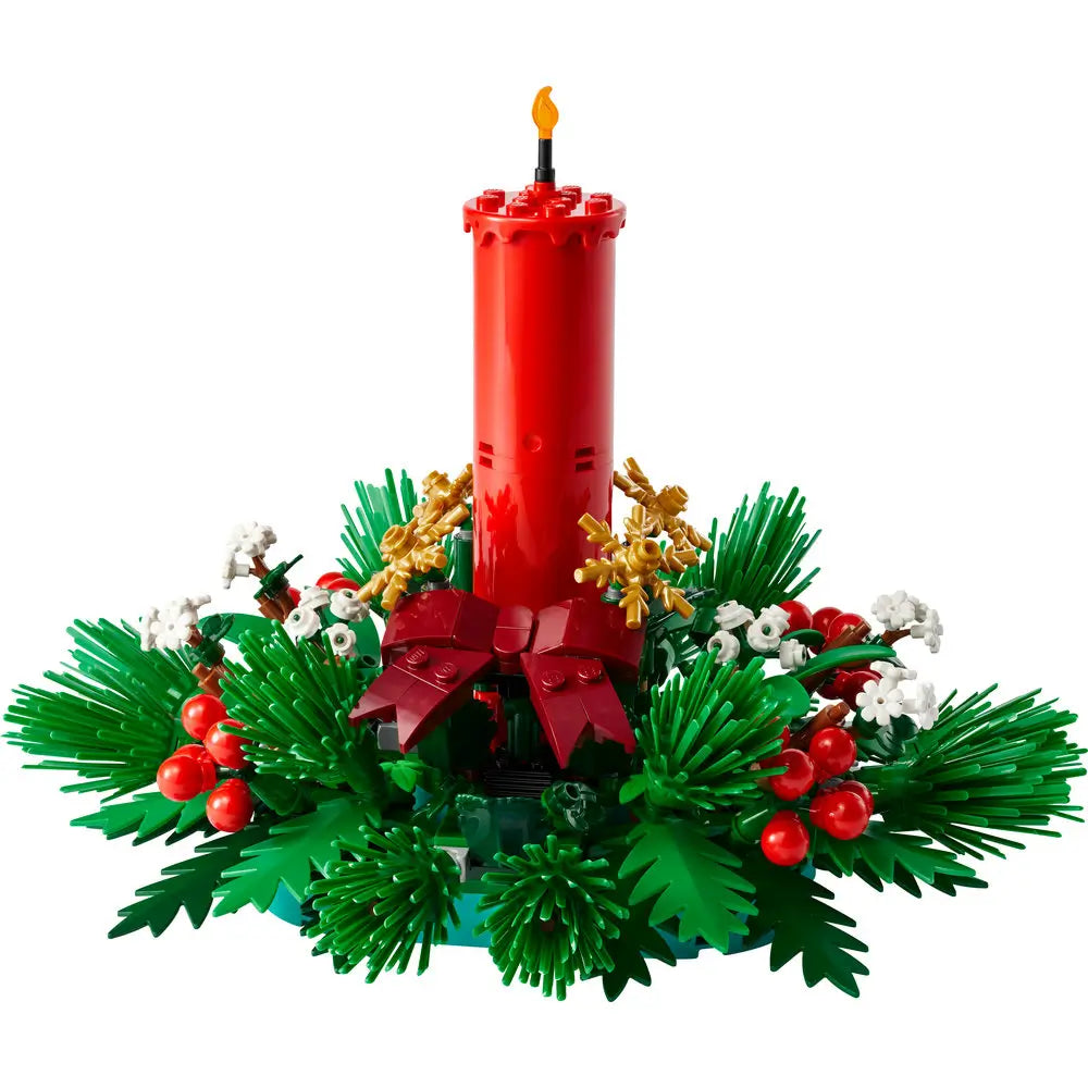 Completed LEGO 40743 Christmas Table Decoration featuring a red candle surrounded by lush green pine branches, red berries, and white blossoms forming a festive round centerpiece.
