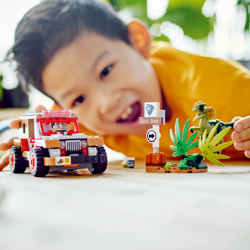 Boy playing with the LEGO® Jurassic World Dilophosaurus Ambush 211 Piece Building Set