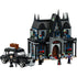 LEGO Wednesday Morticia’s Cottage set showing a gothic-style mansion with steep black roofs, stained glass windows, red roses, and a vintage black car with luggage on top.