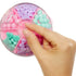 Overhead view of pink LOL Surprise Hair Beads storage ball divided into sections of pastel beads in purple, mint, pink, and heart shapes, with hand lifting the lid.