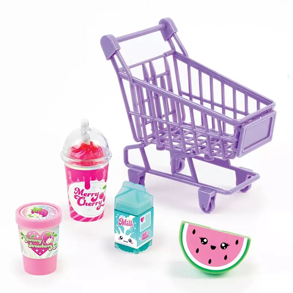 Set of colorful 3C4G lip gloss containers shaped like a milk carton, smoothie cup, ice cream tub, and watermelon slice beside a lavender mini shopping cart on white background.
