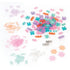 Assorted Linxo jewelry set components in pastel shades of pink, purple, teal, orange, and white plastic pieces shaped like links and flowers, spread on a white surface for bracelet crafting.