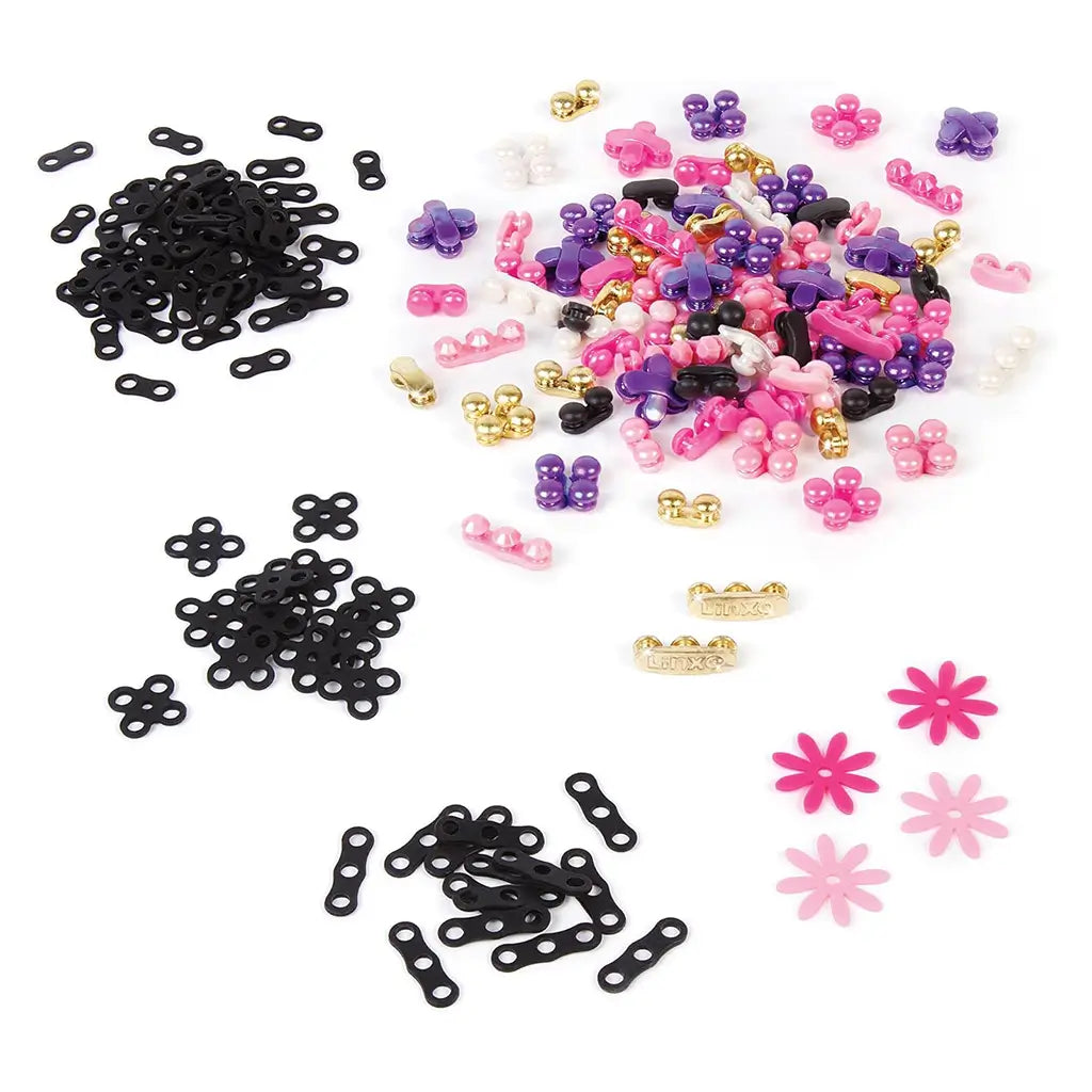 Linxo bracelet-making kit components spread on a white surface, including black connectors, pink and purple beads, golden charms, and flower accents for customizable jewelry designs.