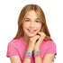 Smiling girl in a pink shirt wearing handmade Linxo Seaside Style bracelets in teal, purple, and coral colors, posing with hands under her chin against a white background.