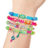 Close-up of a wrist wearing several Make It Real Shrink Magic bracelets, decorated with vibrant beads and fun candy-shaped charms for a playful jewelry look.