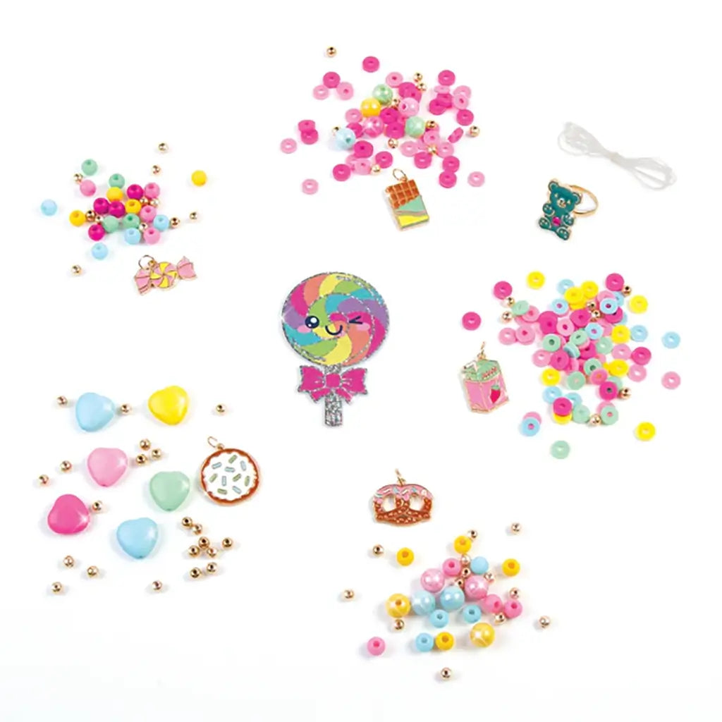 Colorful Make It Real Snackers Bracelet Kit materials including pastel beads, candy-themed charms, and a clear elastic cord arranged neatly on a white background.