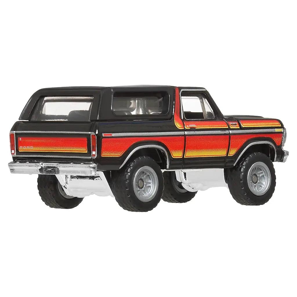 Rear angled view of Matchbox 1978 Ford Bronco die-cast car, black paint with red-orange striping, chrome bumper, raised suspension, and clear rear windows for detail.