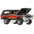 Matchbox 1978 Ford Bronco die-cast truck in black with chrome detailing, hood open to reveal engine design, featuring orange gradient side stripes and rugged stance.