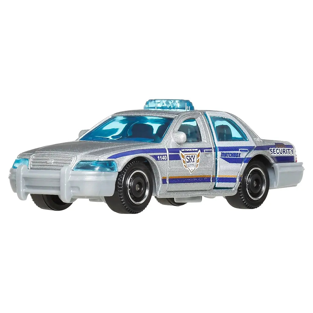 Close-up of Matchbox 1:64 scale silver Ford Crown Victoria security car with blue windows, detailed decals reading SKY Security, black wheels, and a blue light bar on the roof.