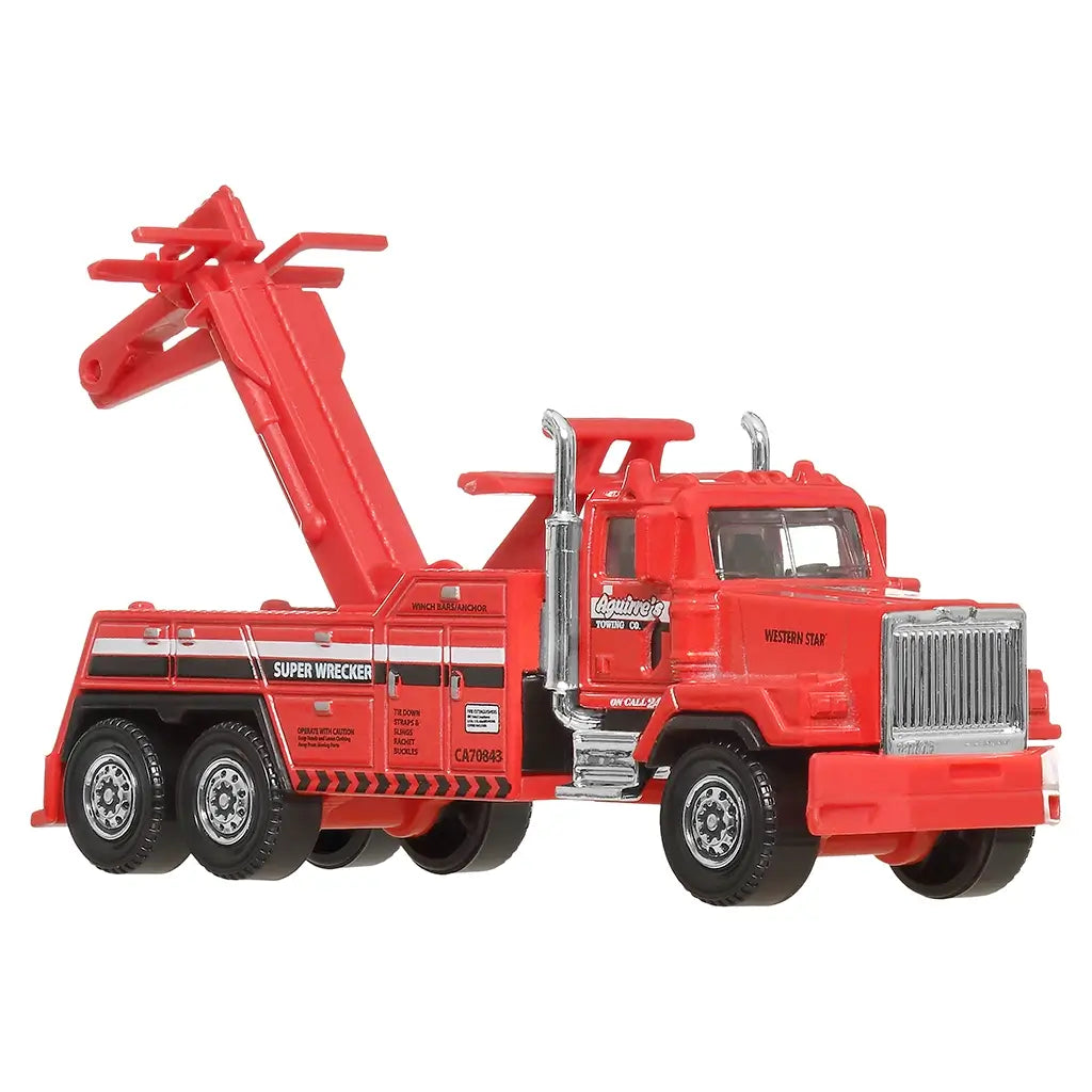 Red Matchbox Western Star 6900XD miniature wrecker truck featuring rotating tow arm, bold black side graphics, and chrome details, displayed side view on plain background.