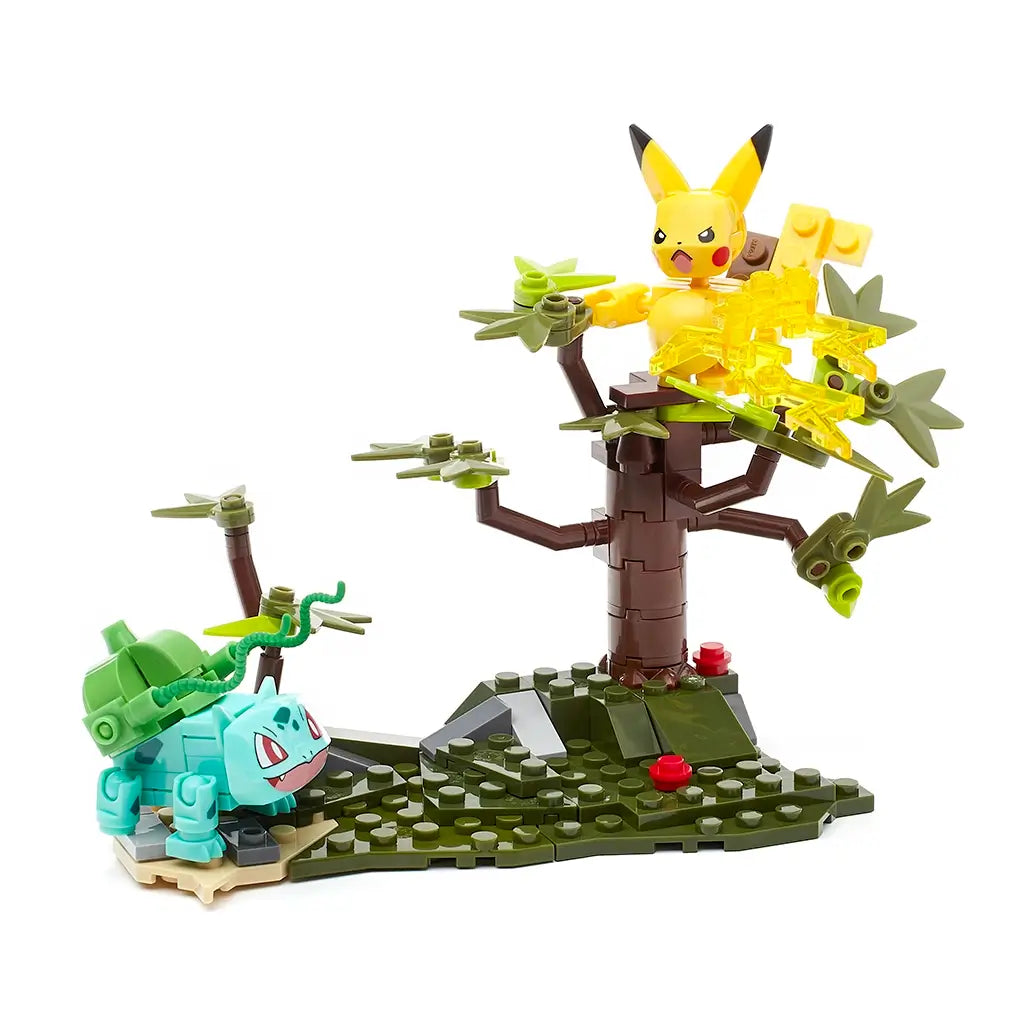 Mega Construx Pokémon playset with Bulbasaur standing on grassy terrain while Pikachu launches electric attacks from a brown tree, creating a dynamic forest battle display.