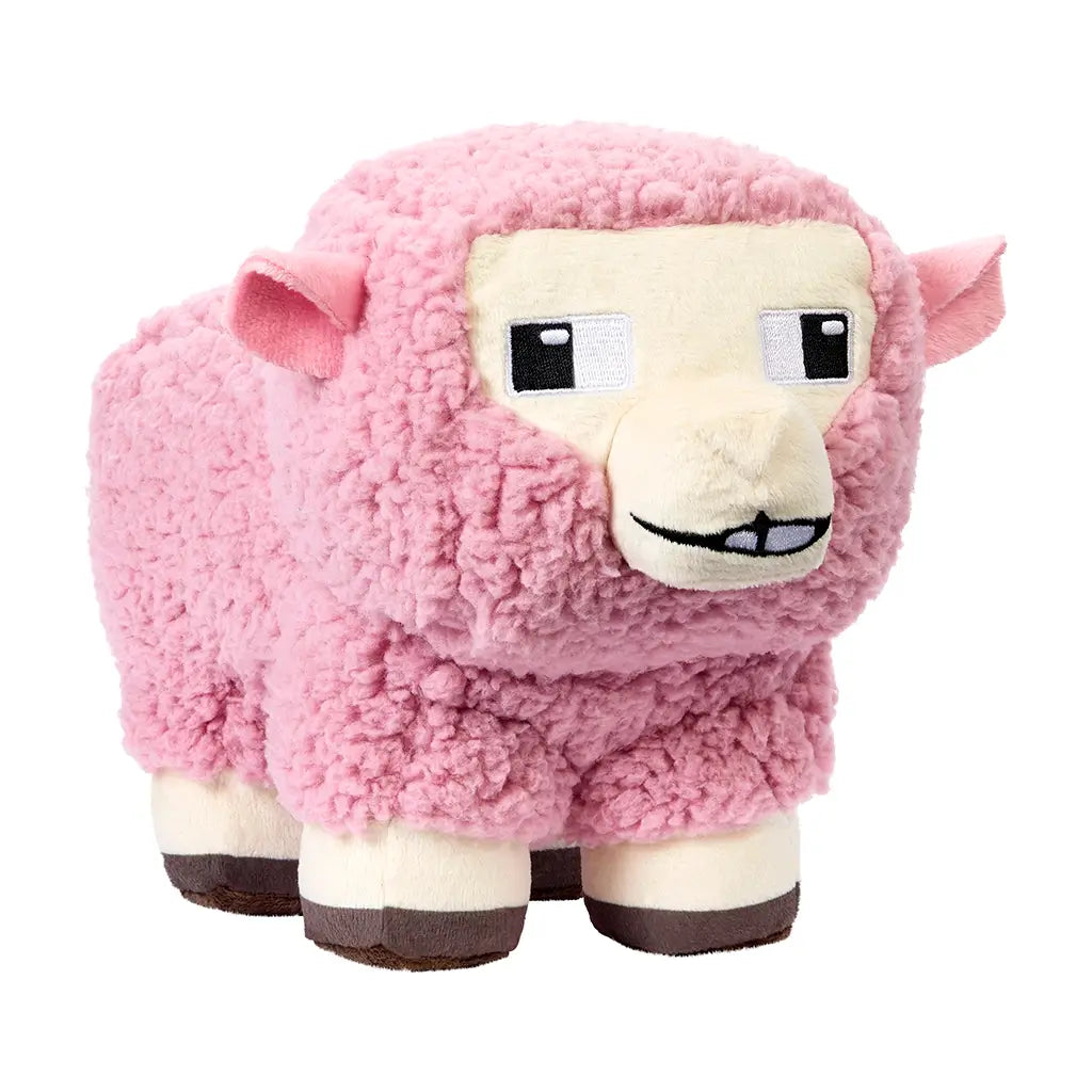 Minecraft Movie pink sheep plush toy angled close view, featuring soft textured pink fleece, pixel-style cream face, black embroidered eyes, stitched smile, and blocky brown hooves for support.