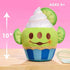 10-inch Disney Munchlings Toy Story Alien lime cupcake plush displayed on a wooden surface with a pink background, showing green body, white swirl top, lime slice ears, and text for ages 0 and up.
