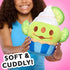 Disney Munchlings Toy Story Alien lime cupcake plush held by a smiling girl in a blue shirt, showing its soft green fabric, embroidered smile, and blue-striped cupcake base with text reading ‘Soft & Cuddly!’