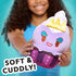 Disney Munchlings plush toy styled as Ursula from The Little Mermaid in a lavender cupcake design with blue eyeshadow, red lips, and a golden crown, held by a smiling girl with a turquoise background.