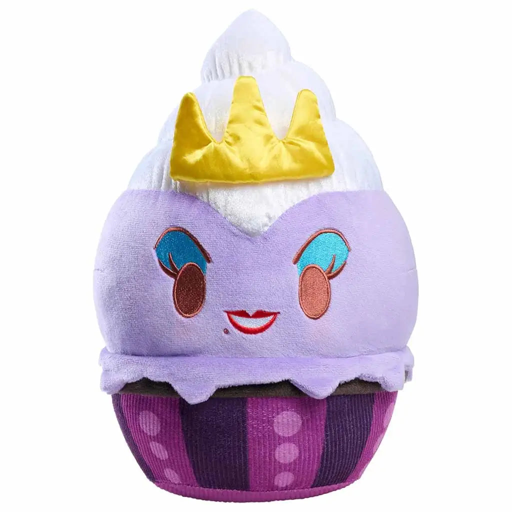 Studio shot of Disney Munchlings Ursula plush toy designed like a purple cupcake with white whipped topping and gold crown, featuring embroidered eyes, red lips, and soft fabric texture for display or cuddles.