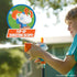 Nerf Super Soaker Quadblast being used by a child outdoors, spraying water with an inset showing the blaster’s bright orange flip-up targeting scope feature for improved water aiming accuracy.