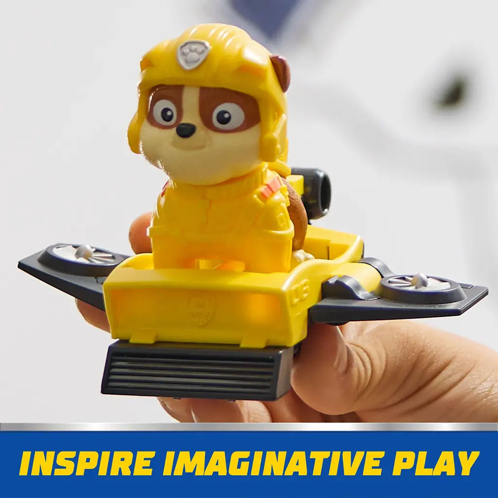 PAW Patrol Rubble figure riding yellow hoverboard with black rotors, held in child's hand to inspire adventurous and imaginative playtime.