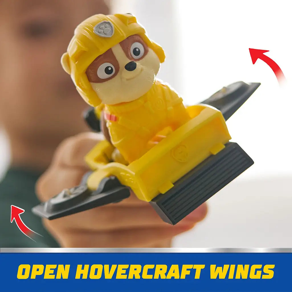 PAW Patrol Rubble figure in yellow gear shown flying hoverboard with black wings extended, promoting creative storytelling and rescue missions.