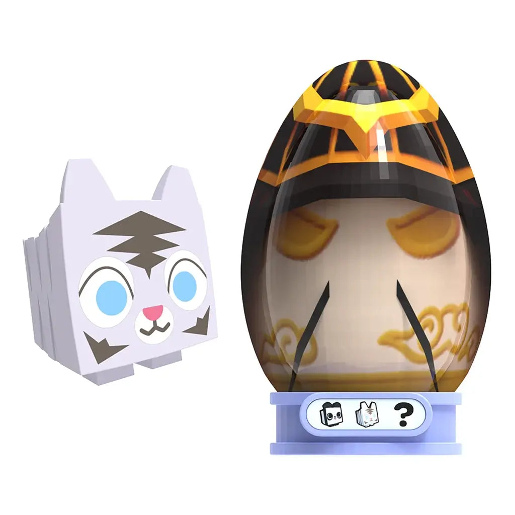 PhatMojo Pet Simulator Series 2 white cat toy with blue eyes beside a black and gold egg with closed eyes and ornate details, displayed on blue base stand.