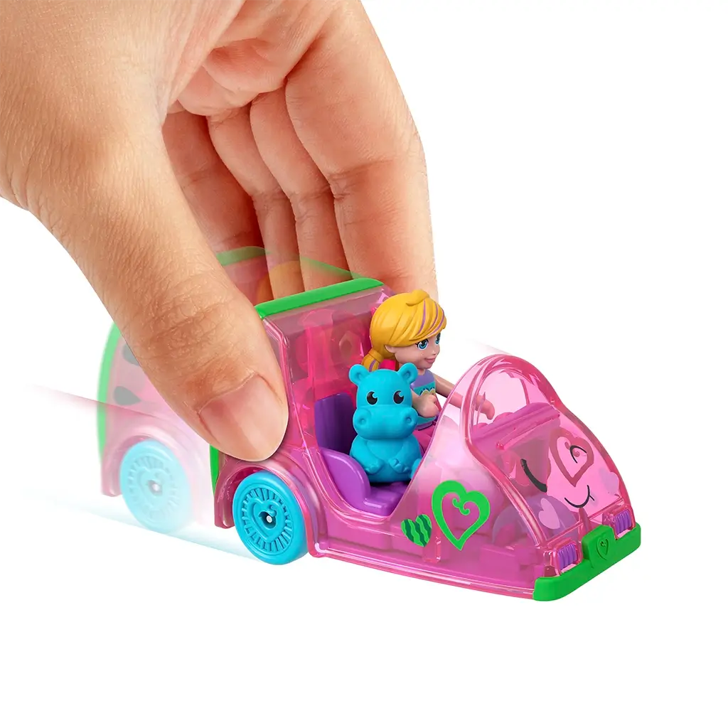 Hand pushing Polly Pocket pink watermelon car with green trim, seated Polly doll, and blue hippo figure, demonstrating toy in action on white background.
