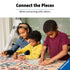 Mother and two children work together on a Ravensburger Batman puzzle at a table, focusing intently as they connect colorful jigsaw pieces for a fun family bonding activity.