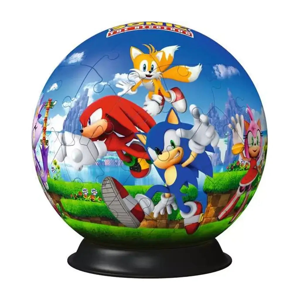 Close-up of completed Ravensburger 3D puzzle ball with Sonic, Knuckles, Tails, and Amy in a colorful, detailed video game landscape on a black stand.