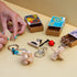 Brain teaser puzzles with wood, metal, and rope designs displayed on a table with colorful matchbox-style packaging, showing hands interacting with triangle pieces.